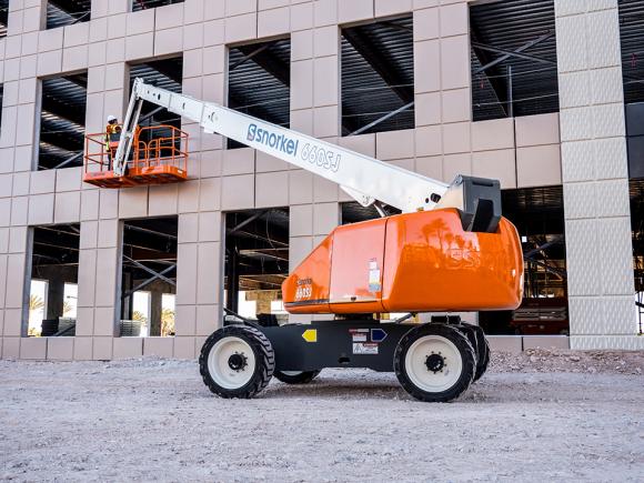 Orange, white and grey telescopic boom lift with construction worker in platform